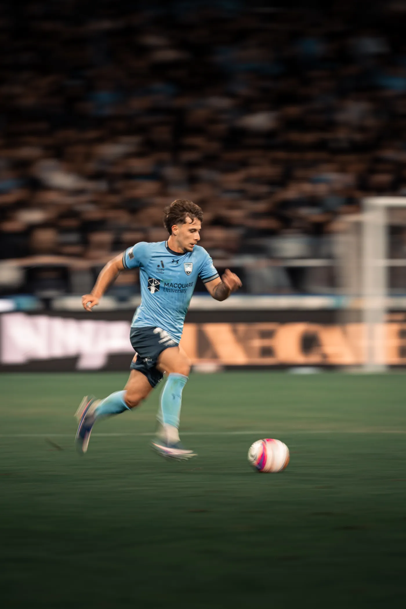 Sydney FC player driving the ball forward with motion blur