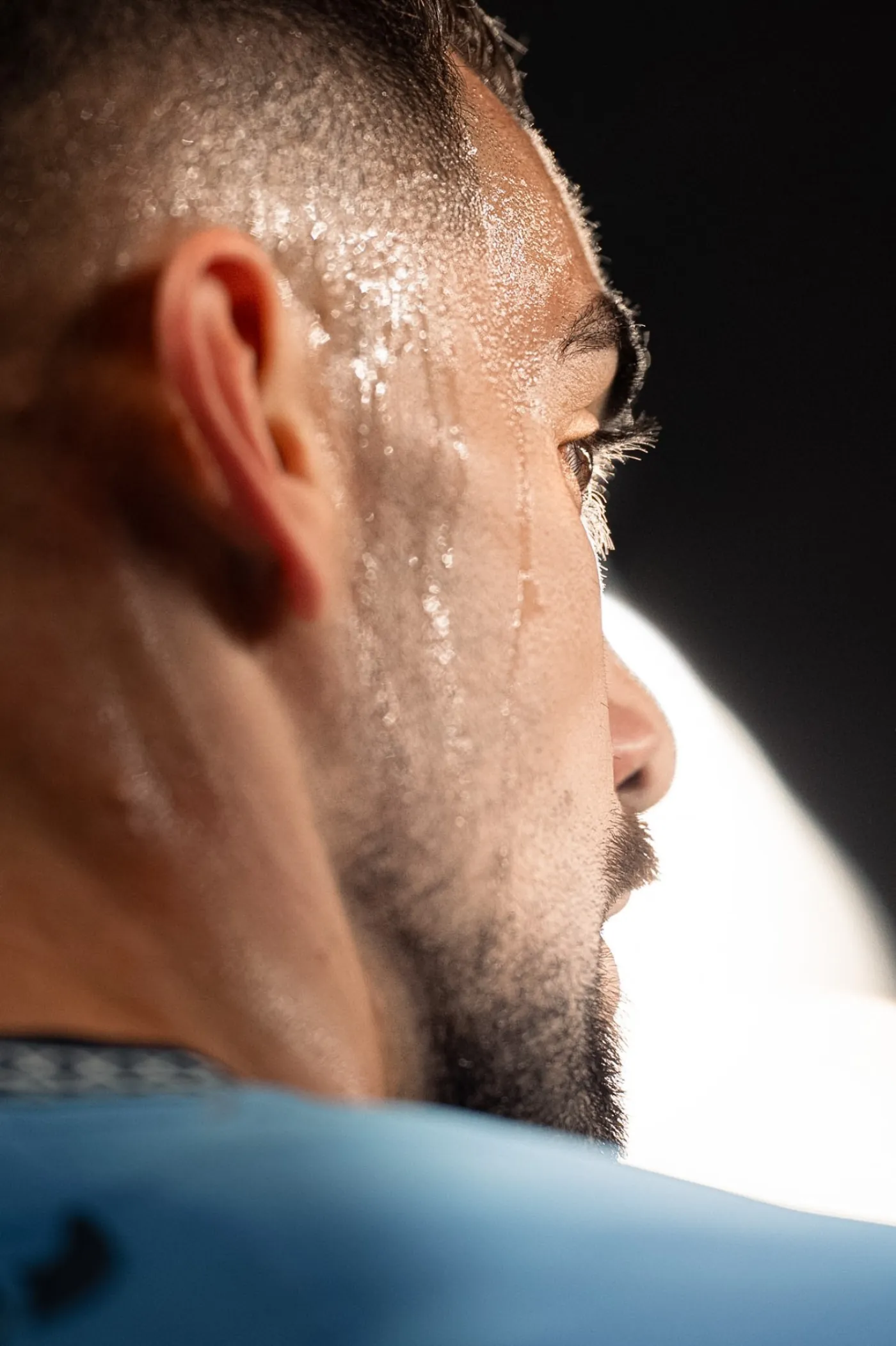 Close-up profile of a sweat-soaked player under stadium lights